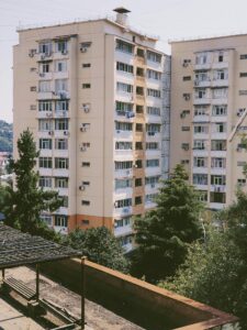 High-rise residential buildings with lush trees and clear sky, creating an urban contrast.